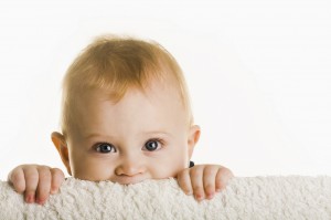 Baby peeking over blanket