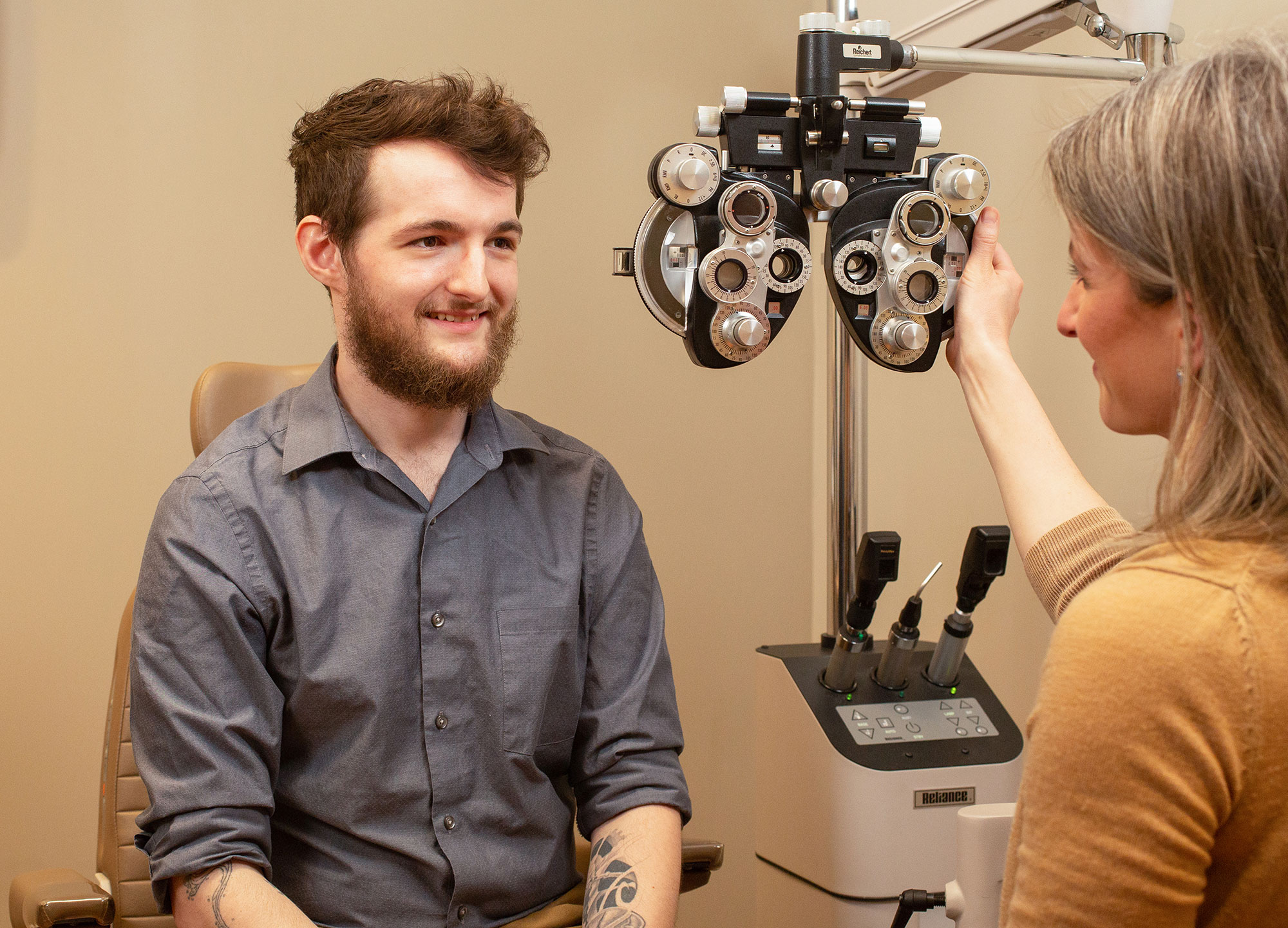 A young man speaks with his eye doctor about his exam results. 